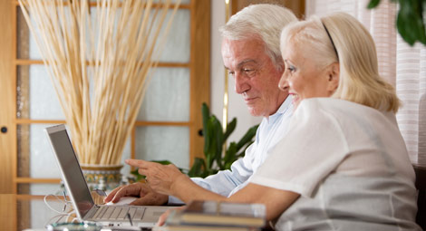 An older man and lady using a laptop